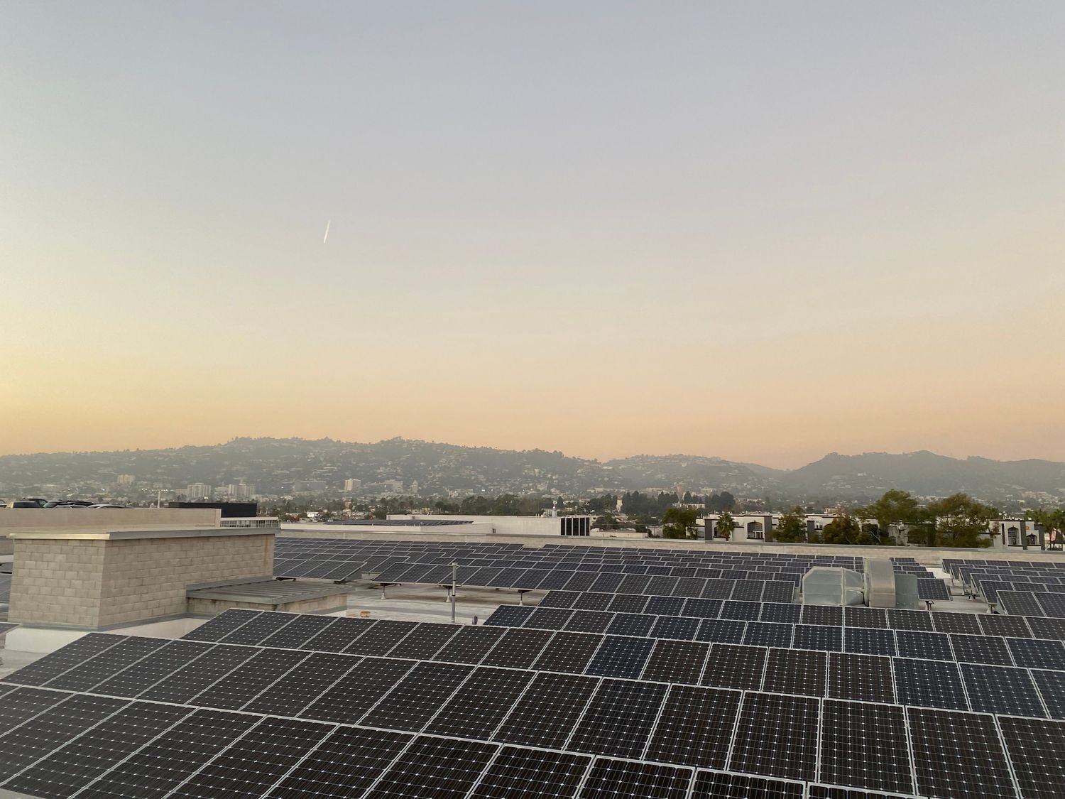 Planta solar fotovoltaica sobre la cubierta de un edificio al atardecer